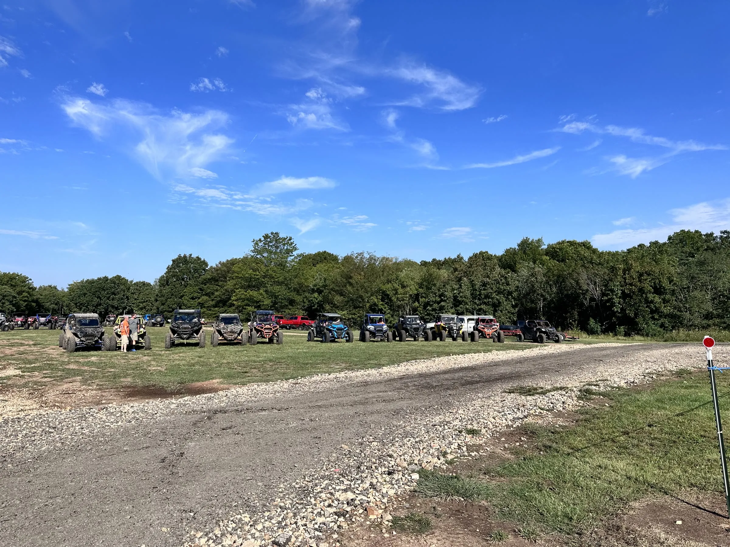 A row of parked UTVs and side-by-sides lined up at the park