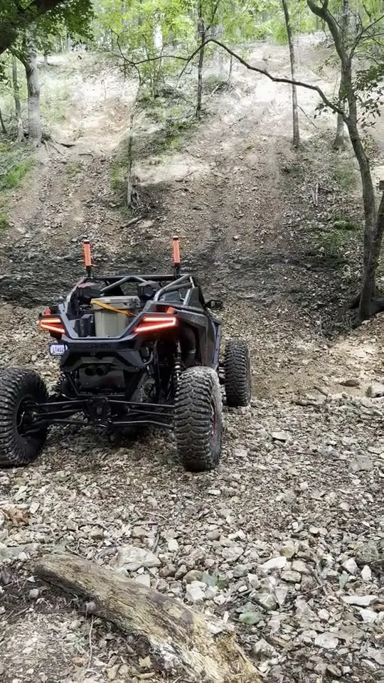 Riding a RZR through the woods on a dirt trail